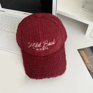 Detail of burgundy fleece baseball cap featuring white Mild Back WINTER embroidery text