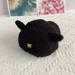 Détail de la casquette en polaire sherpa noire avec oreilles d'animaux et broderie