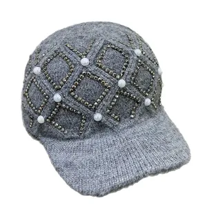 Detail der grauen Strickmütze mit Strass-Gittermuster und Perlenverzierungen