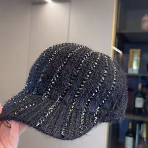 Dettaglio del cappellino in maglia con ricami di perline pesanti e strass scintillanti