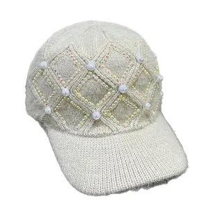 Detail einer Strick-Baseballkappe mit weißen Perlen und schillerndem Strass-Rautenmuster
