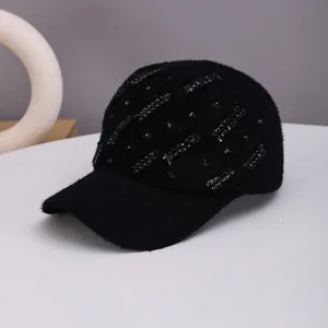 Detailed view of black knitted baseball cap with sequins and fluffy faux mink texture