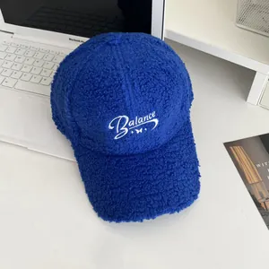 Detail of Klein blue sherpa baseball cap with white Balance embroidery on a laptop