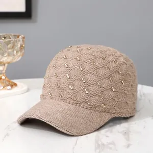 Detailed texture of light brown knit baseball cap with sparkling golden rhinestones