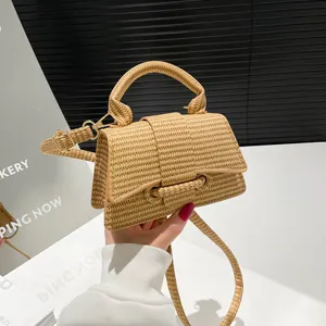 French style straw woven hourglass handbag with gold hardware and a detachable strap
