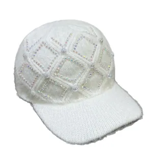 Detailaufnahme einer weißen Strick-Basecap mit glänzenden Strasssteinen und Perlenbesatz