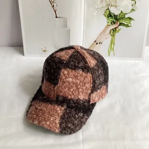 Detailed view of brown and pink checkered teddy fleece baseball cap with fuzzy texture