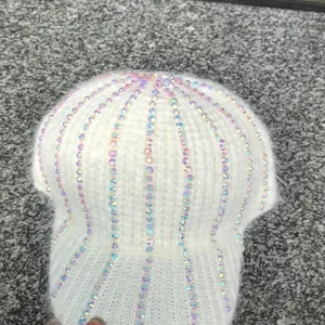 Dettaglio del berretto in maglia bianca con strass colorati brillanti e texture morbida