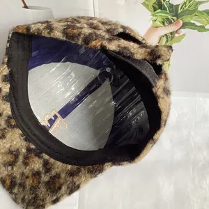 Detail view of leopard print plush hat interior featuring a golden embroidered F logo