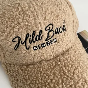 Close-up of khaki lamb fleece texture and embroidered Mild Back lettering on baseball cap