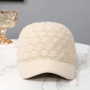 Detailed knit texture of beige baseball cap with subtle iridescent sequins and patterns