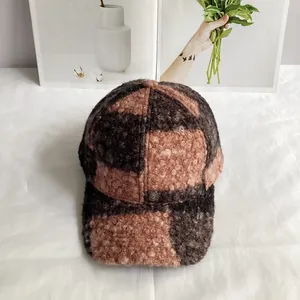 Close-up of color-block teddy fleece baseball cap with thick textured plaid fabric
