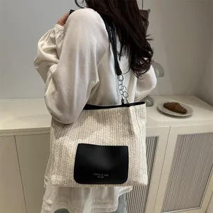 Chic woven straw tote bag with black leather pocket and chain strap for beach vacations