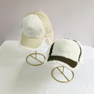 Detail of warm winter trapper hats with thick plush lining and ear flaps on stands