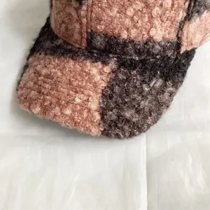 Detailed close-up of pink and grey checkerboard pattern on thick teddy fleece baseball cap
