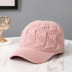 Detailstruktur einer hellrosa Strickmütze mit funkelnden Strass-Dreiecken für Damen