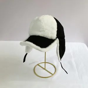 Detail of black and white plush earflap trapper hat with soft faux fur texture