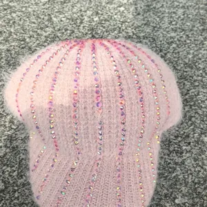 Dettaglio di berretto rosa in maglia con strass luccicanti e morbida trama mohair
