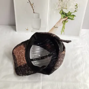 Detail view of the thick checkered wool texture and interior lining of the baseball cap
