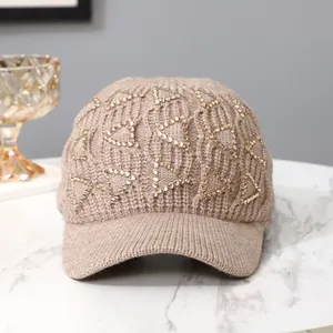 Detailaufnahme der Strickmütze mit goldenen Strass-Dreiecken in Hellbraun