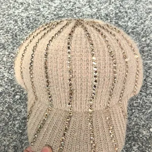 Dettaglio cappello in maglia con strass color oro champagne e morbida consistenza calda