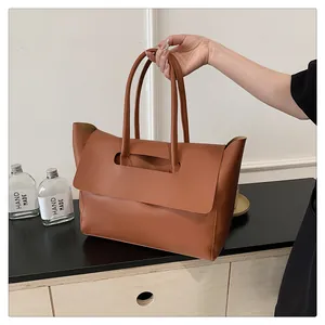 Close-up of caramel leather tote bag showing large capacity and long shoulder straps