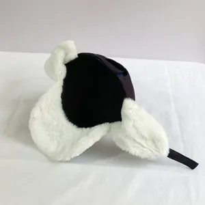 Close-up of windproof trapper hat with soft white fleece lining and navy blue outer fabric