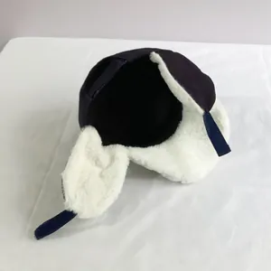 Detail view of the thick white faux fur lining inside the navy blue trapper hat