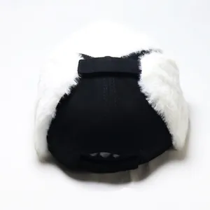 Detailed view of plush faux fur earflaps on a black and white aviator trapper hat