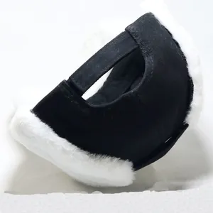 Detailed view of the thick white faux fur lining and black twill fabric of the winter hat