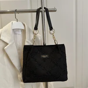 Black jacquard tote bag with diamond pattern and gold chain strap for daily commute