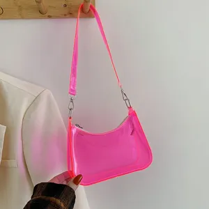 Detail of neon pink transparent PVC shoulder bag featuring silver metal zipper and hardware