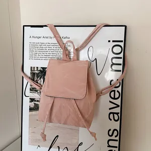 Pink minimalist vintage mini backpack with crinkled texture on a textured background