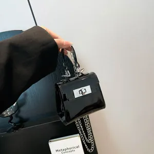Mini bolso bandolera de charol negro con cadena plateada y cierre de metal