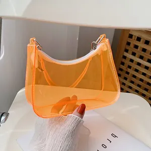 Close-up of bright orange transparent PVC shoulder bag with sleek white zipper detail