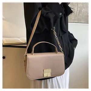 Detail van beige crossbodytas met gouden ketting en vierkante metalen sluiting luxe