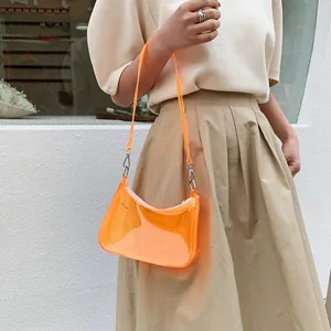 Detail shot of orange transparent PVC underarm bag with silver metal zipper and buckle
