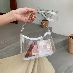 Detail of transparent PVC hobo bag with silver hardware and visible interior cosmetics