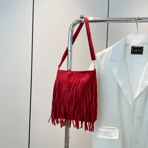Red frosted PU shoulder bag with long fringes hanging on a metal hanger with white blazer