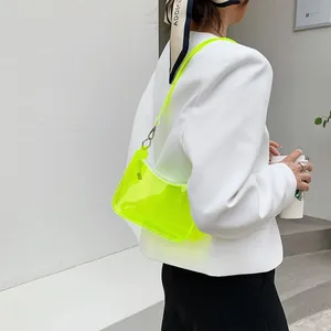 Neon yellow transparent jelly shoulder bag worn with a white blazer for a chic summer look