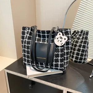 Chic black and white tweed plaid tote bag with shoulder straps and leather patch