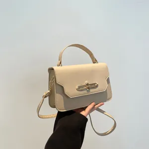 Minimalist beige crossbody handbag with golden hardware and top handle for women