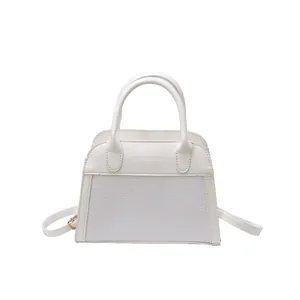 Minimalist white leather handbag with woven texture panels and adjustable strap