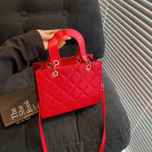 Κομψή κόκκινη καπιτονέ τσάντα με χρυσά αξεσουάρ και κλασικό σχέδιο ραφής