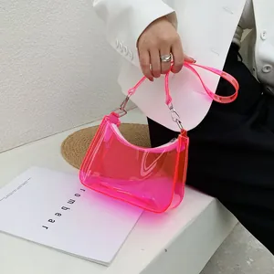 Detailed view of neon pink transparent PVC underarm bag with metallic buckle detail