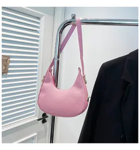 Close-up of pink hobo shoulder bag with woven texture and gold hardware details
