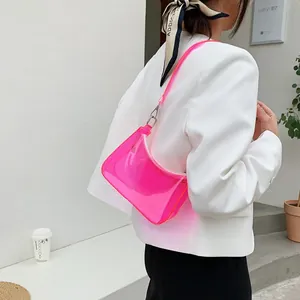 Close-up of vibrant pink transparent PVC jelly bag worn by a model in white outfit