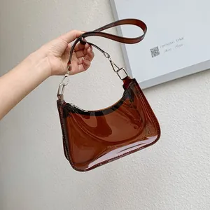 Detailed close-up of dark brown transparent PVC crescent bag with silver metal hooks