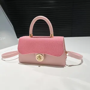 Pink patchwork handbag with golden twist lock and top handle for trendy summer style