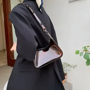 Close-up of brown transparent crescent bag with silver metallic hooks and black zipper
